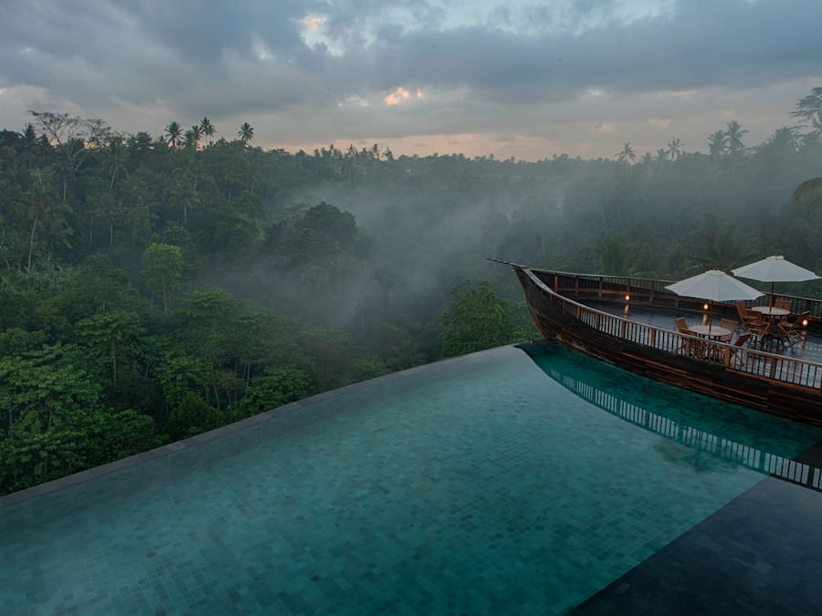 Een buitenzwembad, ligstoelen bij het zwembad