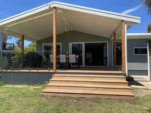 A covered patio with a wooden deck leading to a sliding glass door entrance. - Penguins on Church -800m to Main Street, 120m to beach, 1km to boat ramp (Cowes)