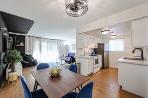 Relax in a spacious living area with a dining table, sofa, and large window.