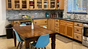 Una cocina moderna con armarios de madera, una mesa de comedor y sillas azules.