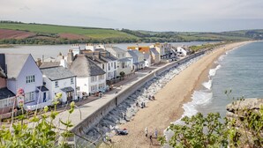 Une ville côtière dotée d’une promenade, de murs en pierre et de bâtiments qui bordent la plage.