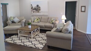 Ein Wohnzimmer mit zwei Sofas, einem Couchtisch und einem gemusterten Teppich.