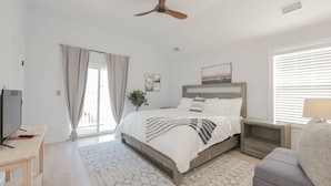 A modern bedroom with a bed, bedside tables, a TV, and a ceiling fan. - 2 Blocks to Beach | Ventnor City | Multi- Level Decks | Pet Friendly (Ventnor City)