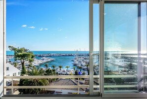A balcony with a view of a marina and the sea.