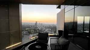 A modern interior with a panoramic city view, a round table, and two sofas.