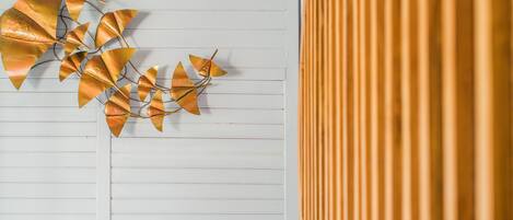 A wall with horizontal lines and a decorative metal leaf arrangement.