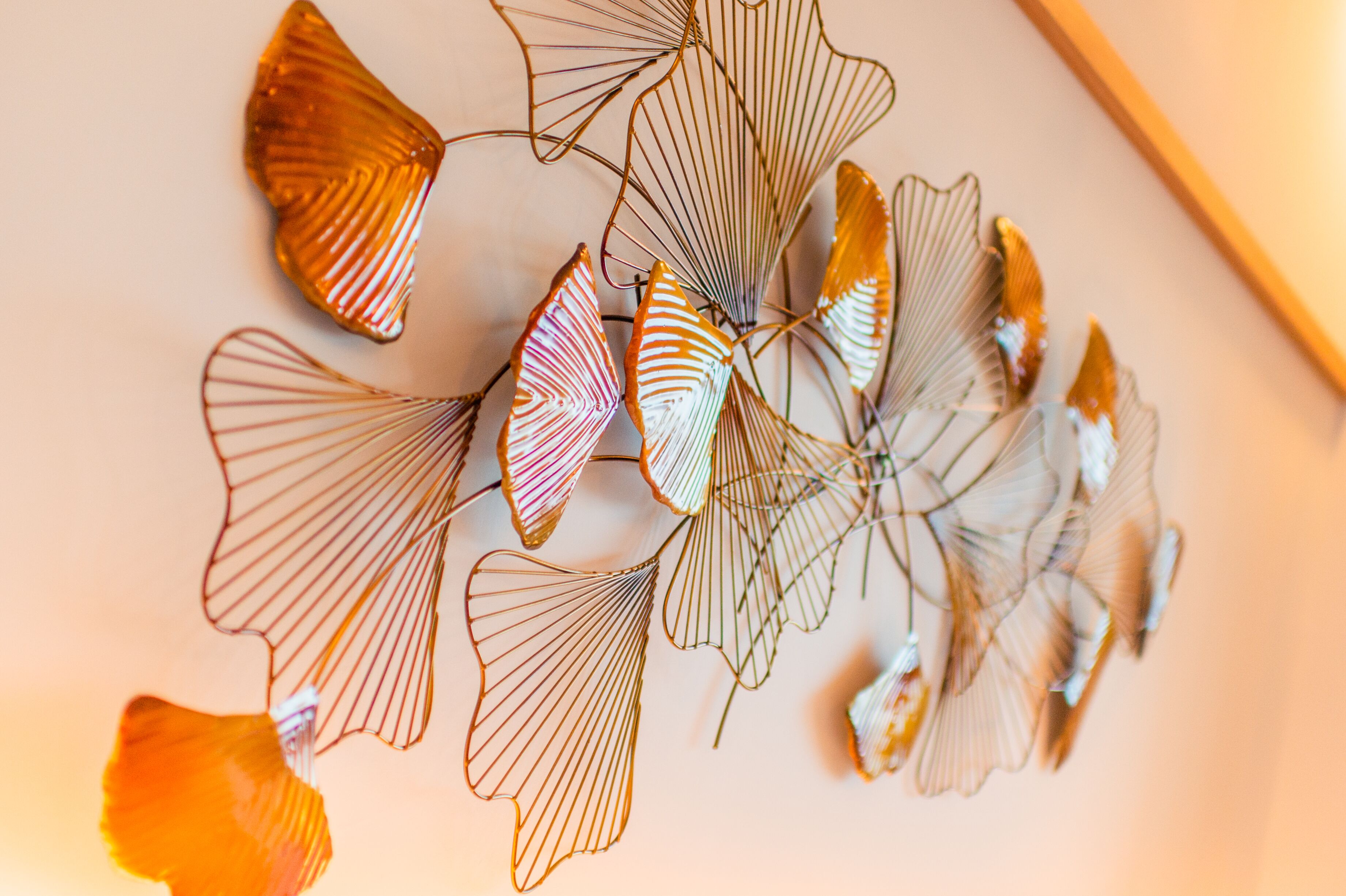 Een decoratieve compositie van metalen bladeren aan een muur.