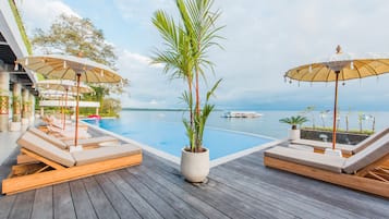 Una piscina al aire libre, sillones reclinables de piscina