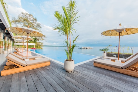 Una piscina al aire libre, sillones reclinables de piscina