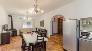Un espacio habitable compacto con comedor, kitchenette y sala de estar.