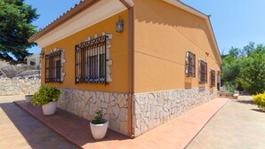 Una casa de dos pisos con base de piedra y fachada amarilla.