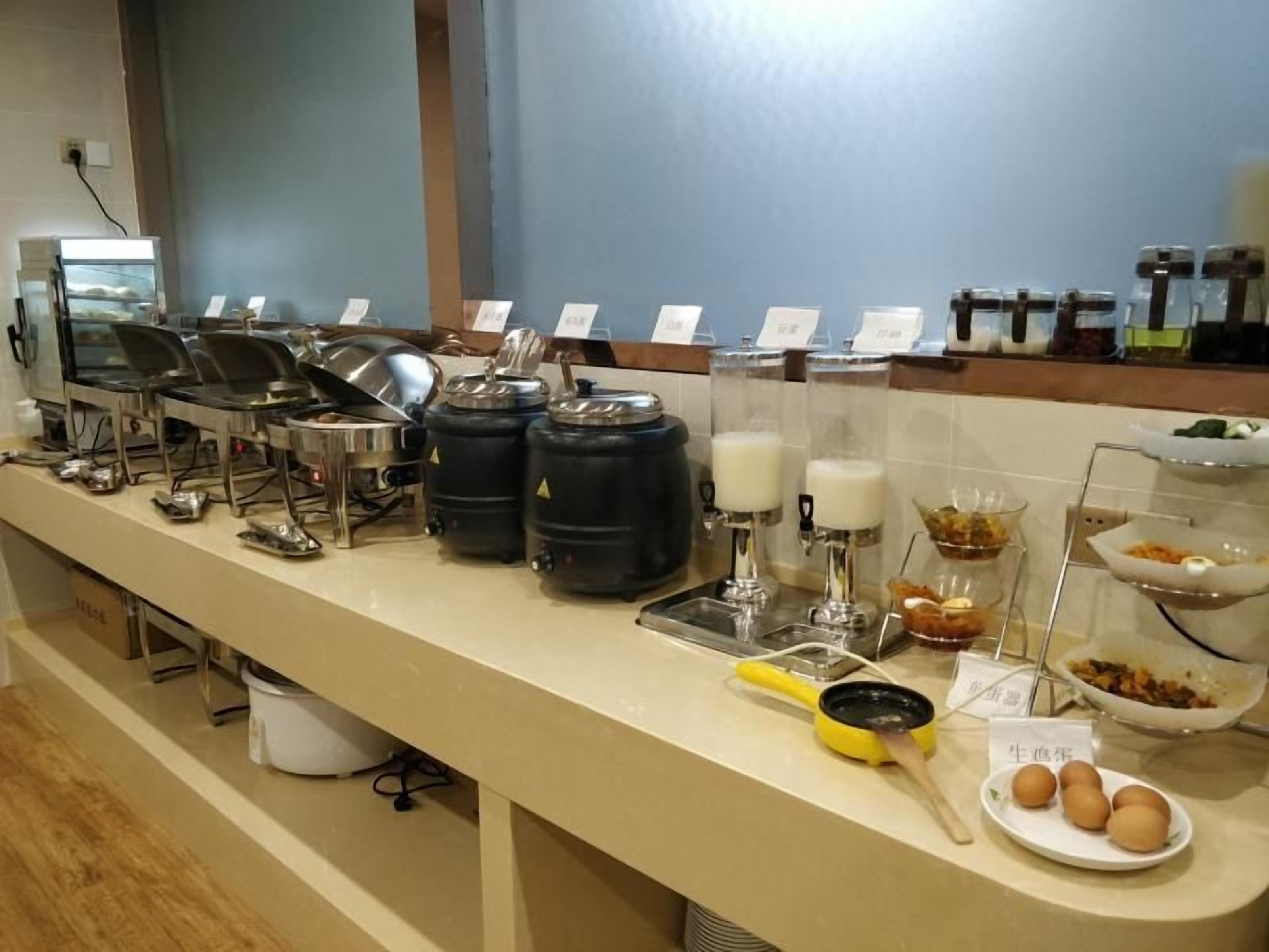A buffet setup with various food stations, including a coffee station and a fruit bowl.