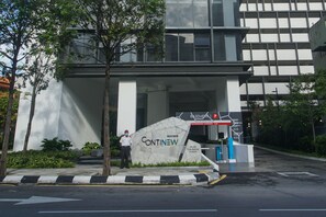 A modern building with a large sign reading "CONTINNEW" and a security guard standing near the entrance.