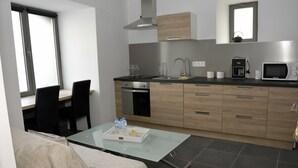 Una cocina moderna con comedor, que incluye un microondas, tetera y una bandeja con botellas de agua.