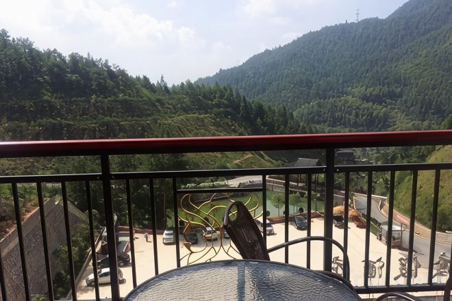 Un balcon donnant sur un parking et un paysage montagneux.