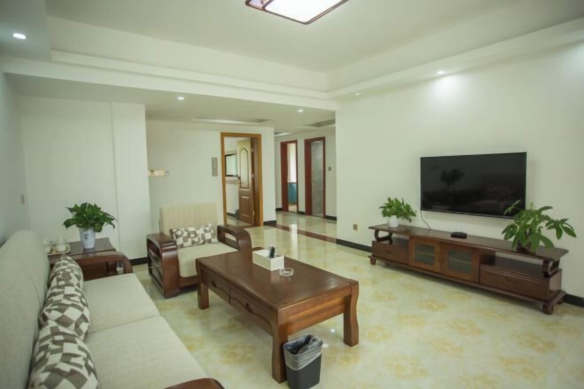 Un salón amplio con sofá, mesa de centro, televisor y aparador.
