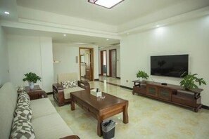 A spacious living room with a sofa, coffee table, TV, and a cabinet.