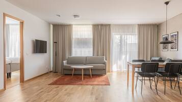 Un salon moderne avec un canapé, une table basse et un coin repas avec des chaises.