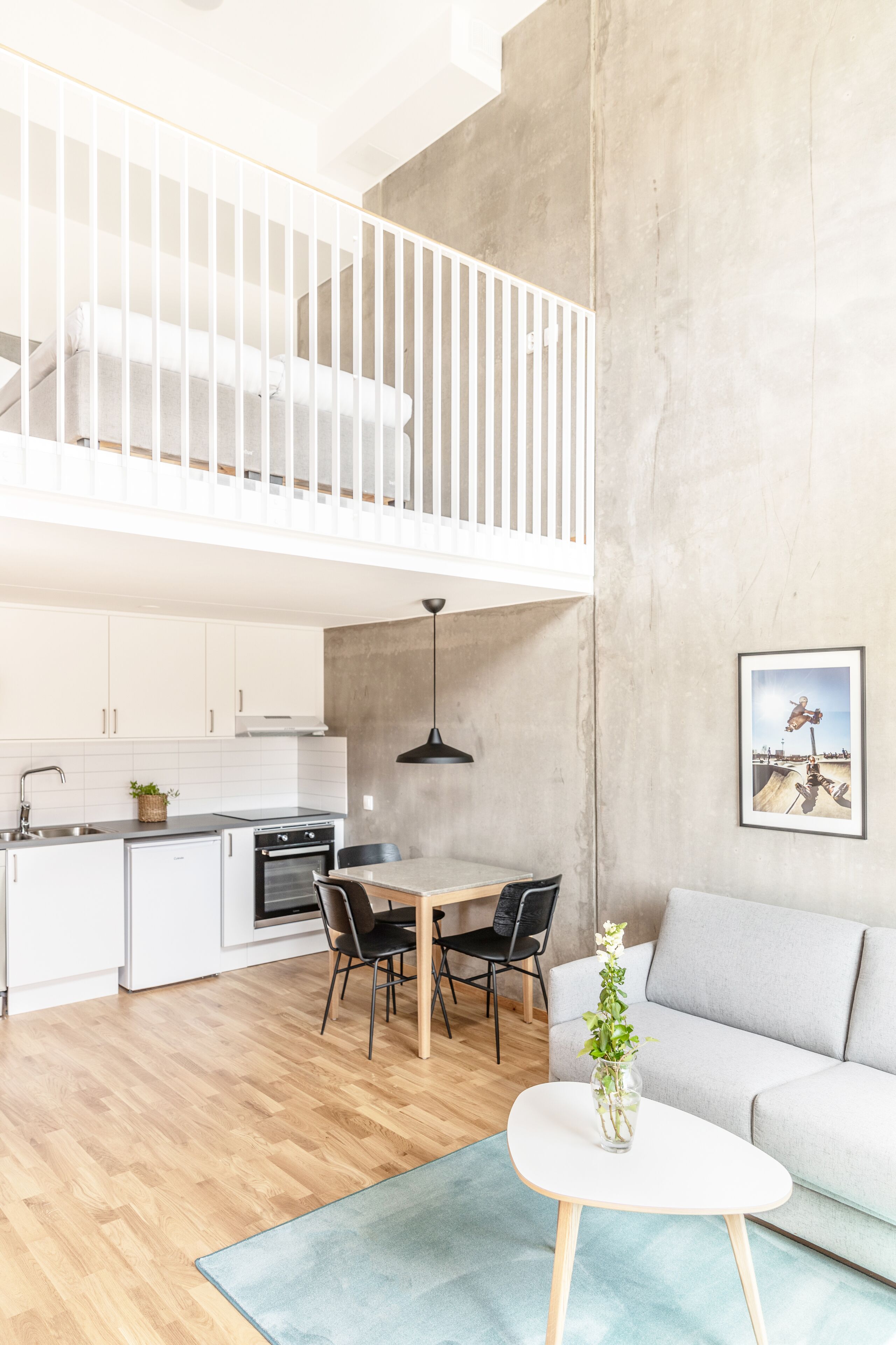 A modern apartment with a loft bedroom, a dining area, and a living room.