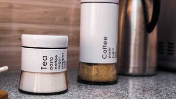 Two containers labeled 'Tea' and 'Coffee' with a coffee maker in the background.