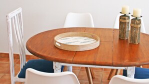 A dining table with a wooden bat, white chairs, and candle holders. - Pet-Friendly Apartment with Sea View, Balconies & A/C (El Port de la Selva)