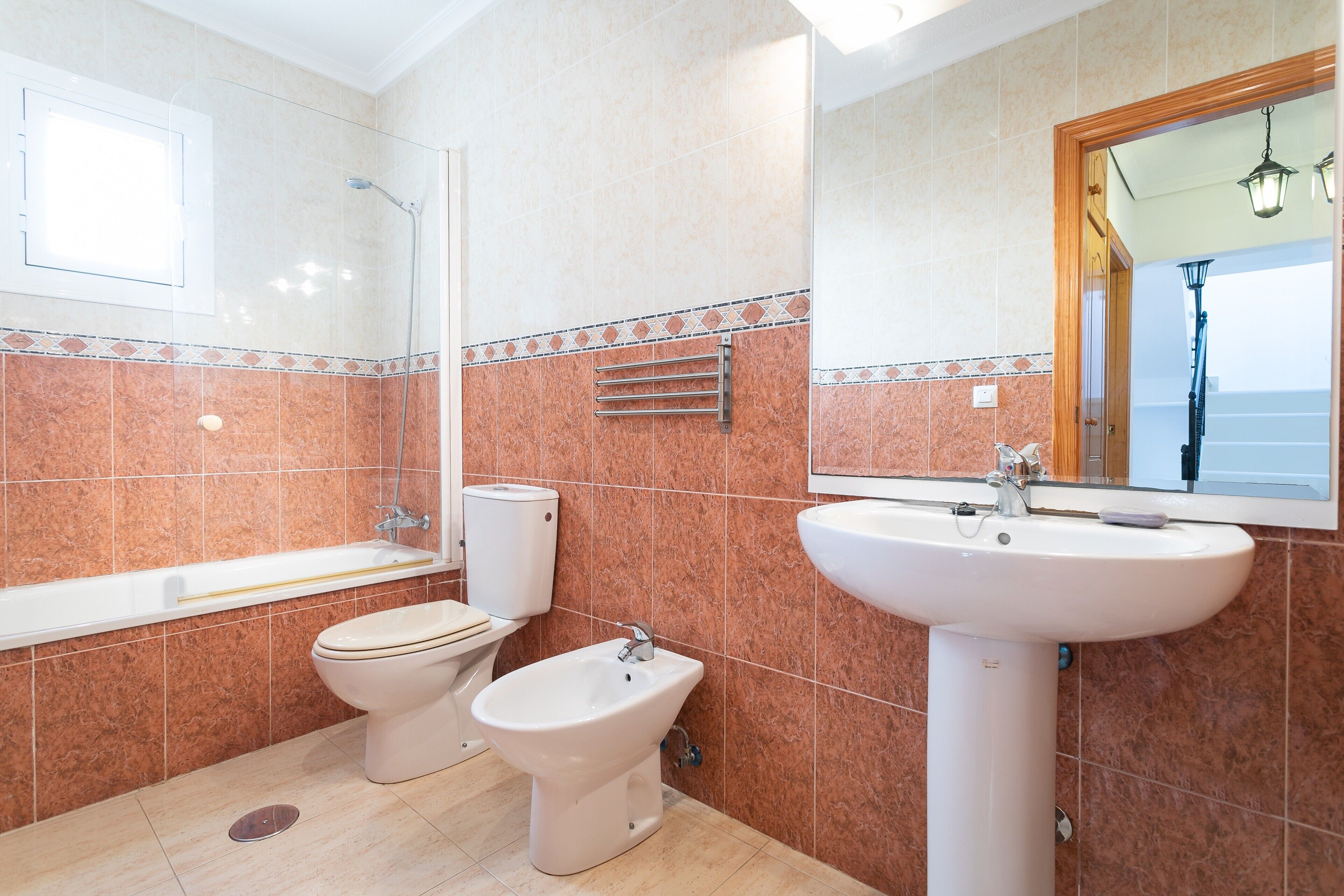 A bathroom with a bathtub, toilet, bidet, and sink.