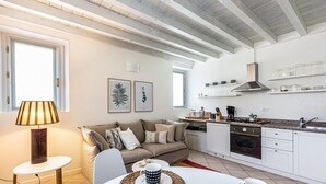 Una cocina moderna con armarios blancos, horno empotrado y campana extractora de acero inoxidable.