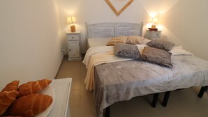 Une chambre à coucher avec un lit, des tables de chevet, des lampes et un tableau encadré au mur.