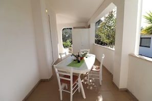 A dining area with a table, chairs, and a bottle of wine.