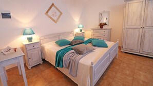 A bedroom with a bed, two bedside tables, a nightstand, a dresser, and a wardrobe. - Apartment "Casa Vacanza Locorotondo Otranto" with Garden, Shared Pool & Wi-Fi (otranto)