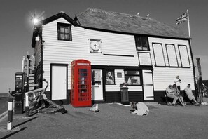 A white building with a red telephone booth, a clock, and a flag. - The Old Chemist - Viking Bay Getaway - Mins To Beach and Town (Kent)