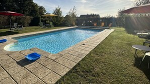 A swimming pool with a tiled deck, surrounded by grass and trees. - Les Hortensias, 3-star self-catering cottage, heated pool, wifi, games... (Monteaux)