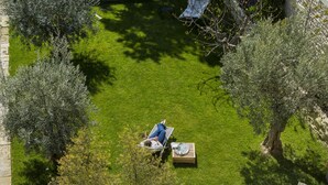 A poolside area with a wooden deck, a dining table with chairs, and a lounge chair. - Le Secret (Saint-Martin-de-Re)