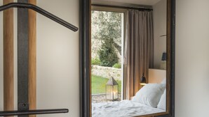 A bedroom with a large window, a bed, a nightstand, and a lamp. - Le Secret (Saint-Martin-de-Re)