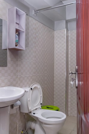 A bathroom with a toilet, sink, and shower.