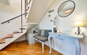 Staircase leads to an upper level, with a cozy seating area and a console table.