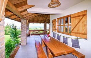 Relax in this charming outdoor seating area, featuring a long bench and table perfect for dining or socializing.