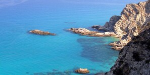 A coastal landscape with clear blue waters and rocky formations. - Il Porticello (Ricadi)