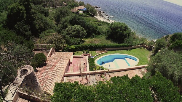 Propiedad residencial con piscina, patio y vista al mar.