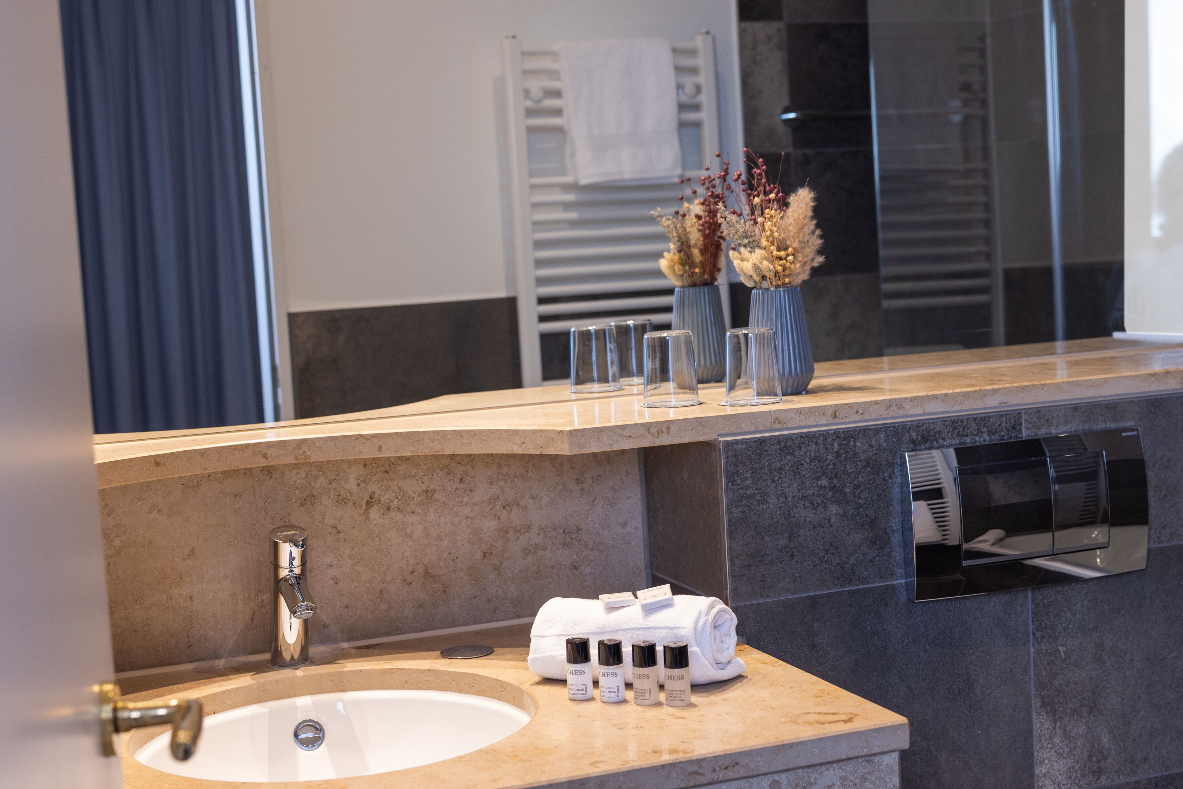Une salle de bain moderne avec un lavabo, un miroir et un porte-serviettes.