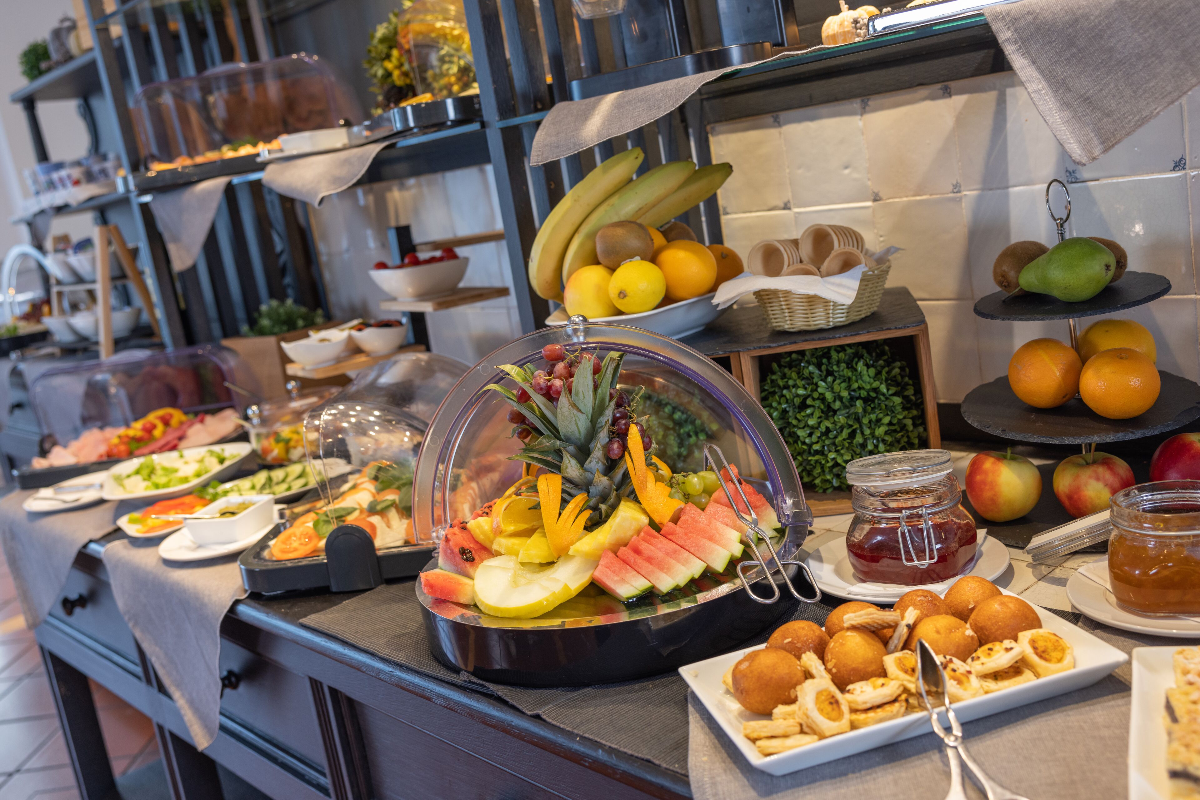 A buffet with a variety of fruits, vegetables, and pastries.