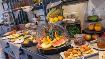 A buffet with a variety of fruits, vegetables, and pastries.