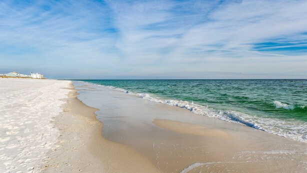 A beach with a clear sky and calm sea.