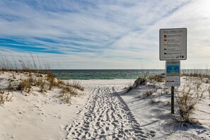 Une plage avec un panneau d’avertissement indiquant que la baignade est interdite et qu’il y a des courants de contre-rivage dangereux.