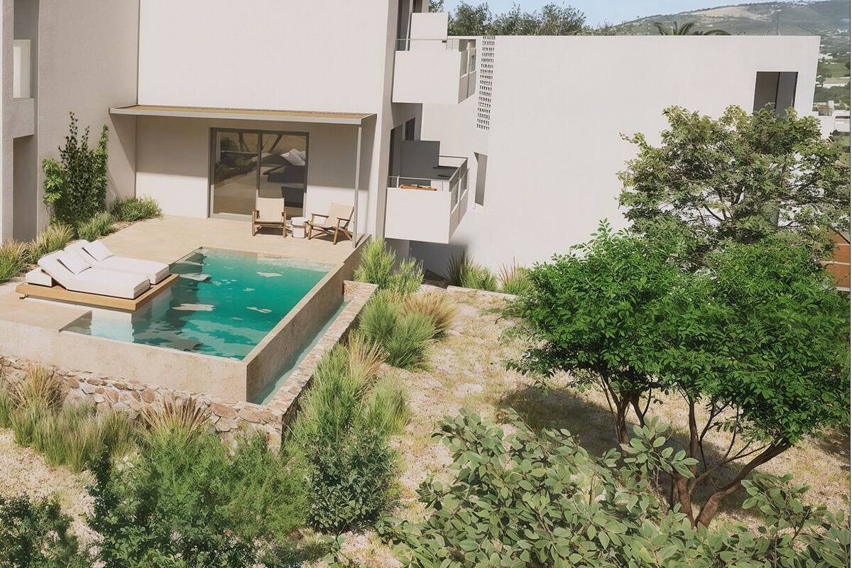 Un edificio moderno con piscina, mobiliario exterior y vistas a las colinas.