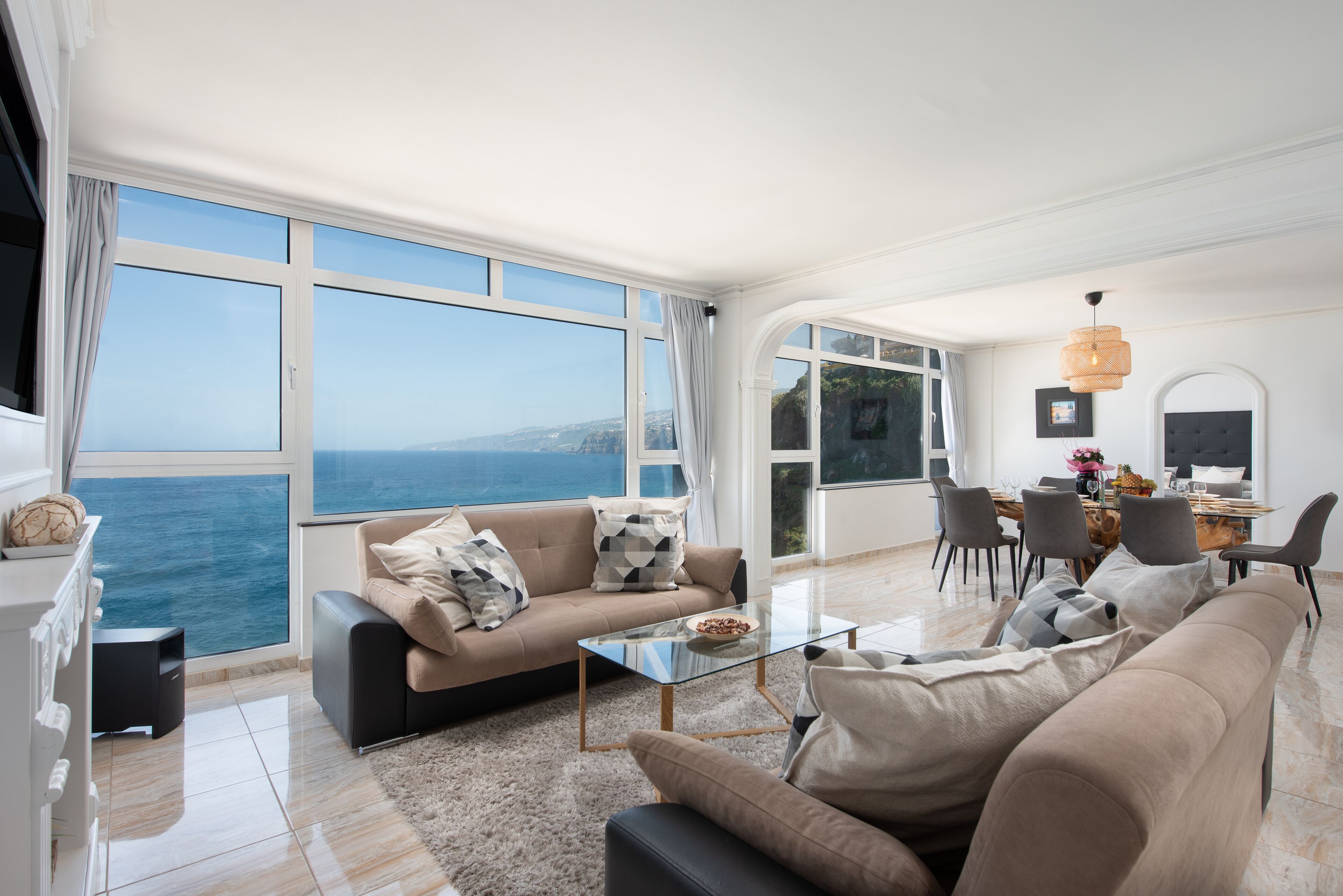 A modern living room with a sofa, coffee table, and dining area.