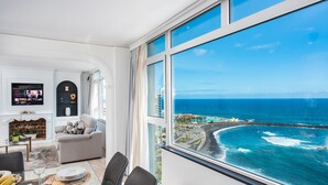 A modern living room with a large window overlooking a coastal view. - Ocean Vistas 24 (Puerto de la Cruz)