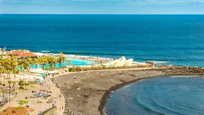 A coastal resort with a beach, a swimming pool, and a rocky shoreline. - Ocean Vistas 24 (Puerto de la Cruz)
