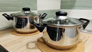 Two stainless steel pots with lids on a wooden countertop. - Central apartment in private area (Barletta)