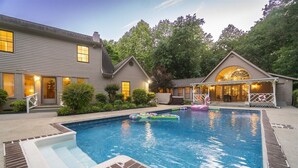 A residential property with a swimming pool, a covered patio, and a house with multiple windows and a porch. - Spacious 5BR Helen villa with private pool, hot tub, and game room. (Helen)